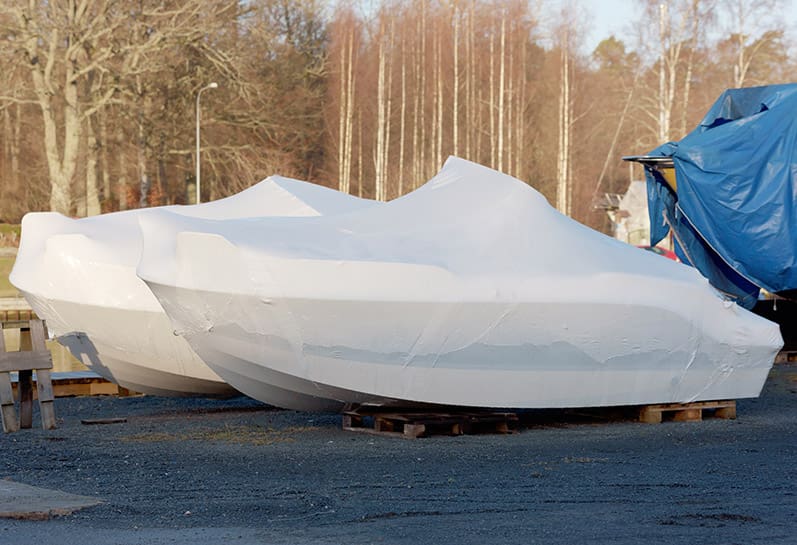 Wrapped boats on stands.