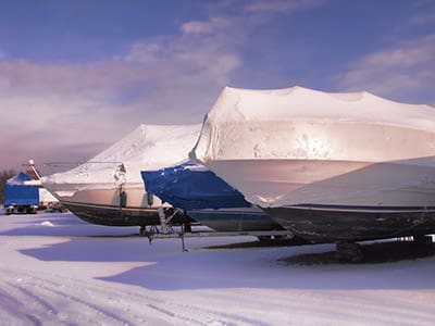 Wrapped boats on trailers in winter.