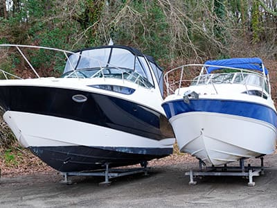 Boats on stands in storage lot.