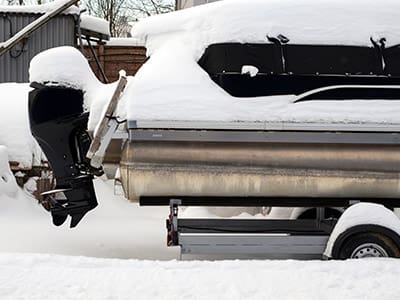 Boat on a trailer covered in snow.